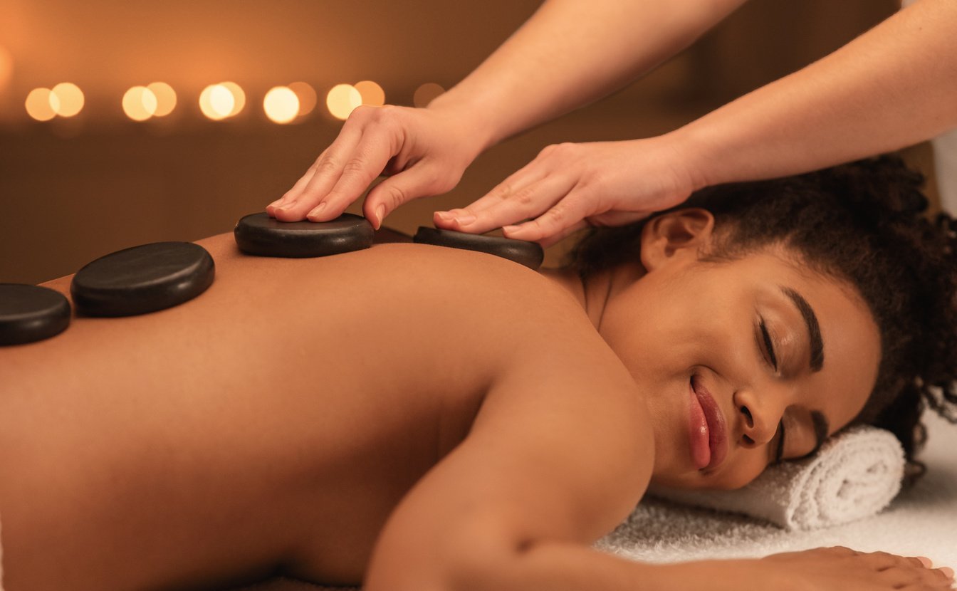 Healing hot stone massage for joyful black woman